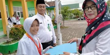 LULU UTFATHUL Jannah Siswi Peraih Juara II Tunggal Putri Tingkat SMP pada Kejuaraan Pencak Silat Satria Cirebon Open 2020 Tingkat Nasional saat menerima penghargaan dari Kepala MTsN 9 Cirebon.*