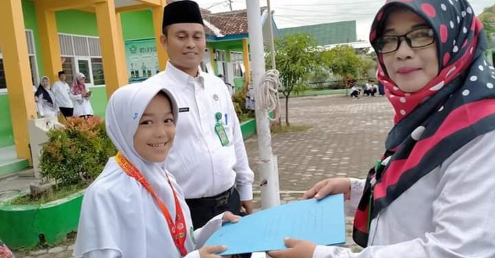 LULU UTFATHUL Jannah Siswi Peraih Juara II Tunggal Putri Tingkat SMP pada Kejuaraan Pencak Silat Satria Cirebon Open 2020 Tingkat Nasional saat menerima penghargaan dari Kepala MTsN 9 Cirebon.*