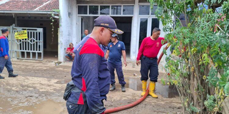 Damkar Berjibaku Bersihkan Lumpur Sisa Banjir