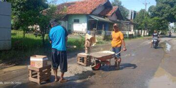 Tak Kunjung Diperbaiki, Warga Leuweunghapit Gotong Royong Tambal Sulam Jalan Kabupaten yang Bolong-bolong